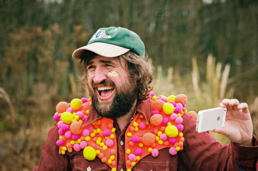 Johnny Lynch of Pictish Trail, wearing a green cap and multi-coloured scarf