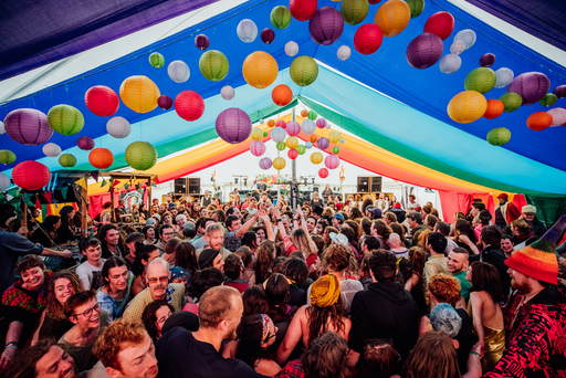 Crowds celebrated under a colourful tent surrounded by balloons and lanterns