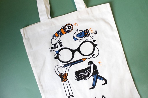 Photo of a tote bag against a green background. Design on the bag shows a group of figures designing a large pair of glasses.