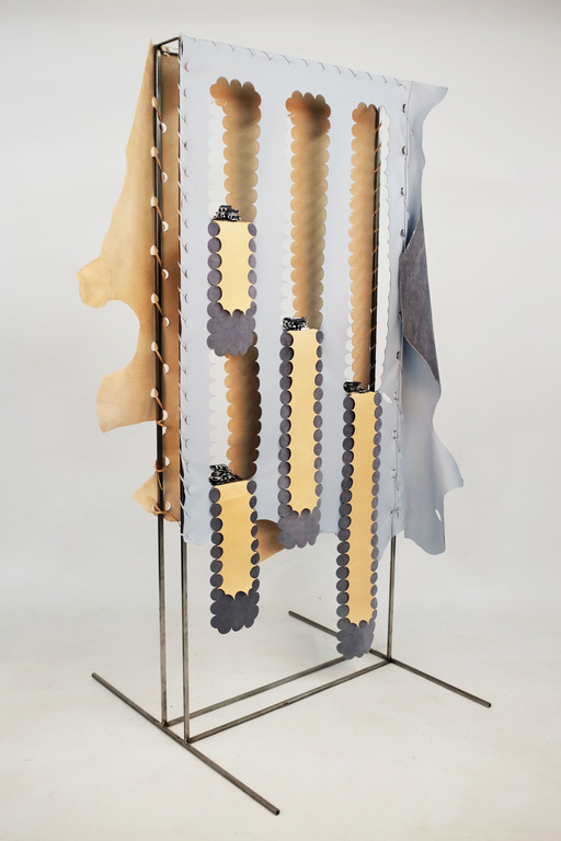 A sculpture by Heather McDonald; a sheet of fabric, with perforated and cut-out sections, is attached to a thin metal frame.