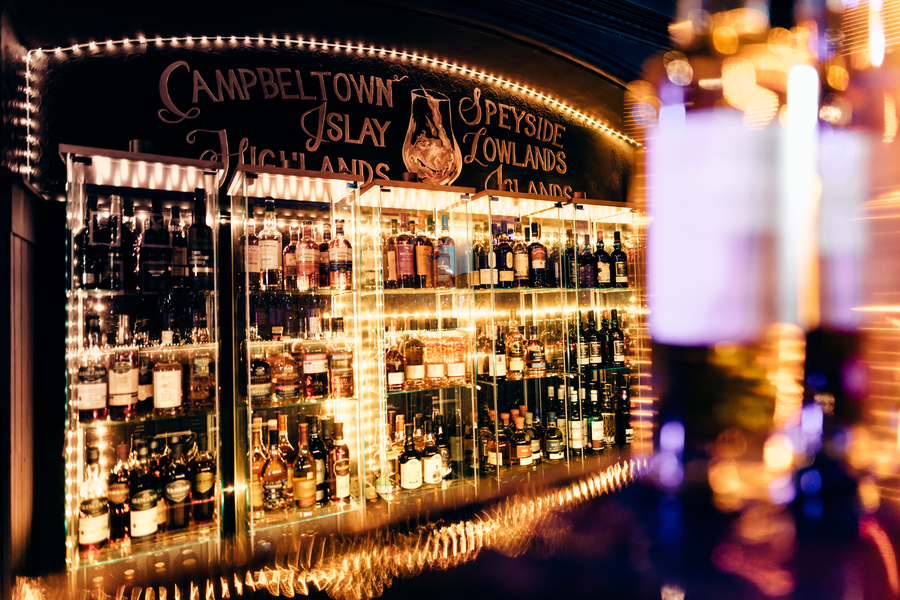 Shelves filled with whisky, surrounded by bright lights.