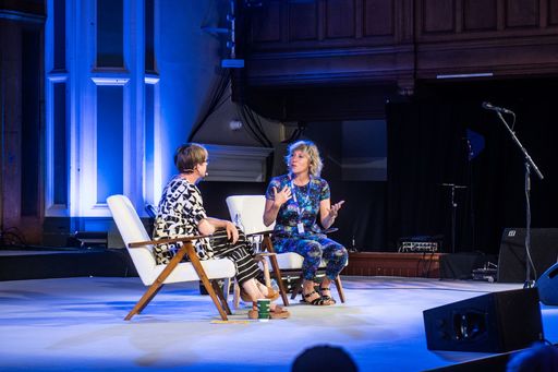 Martha Wainwright and Karine Polwart sit on white lounge chairs on a stage.