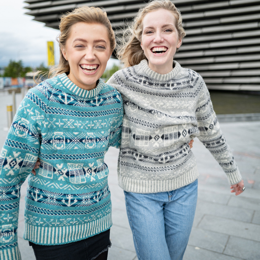 Two women in Fair Isle sweaters stand in front of V&A Dundee.