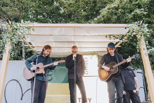 Three members of The National perform on a small stage among a patch of trees at Connect festival.