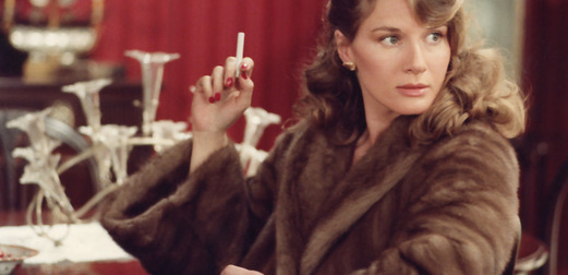 A still from A Room in Town. A woman in a fur coat holds a cigarette.