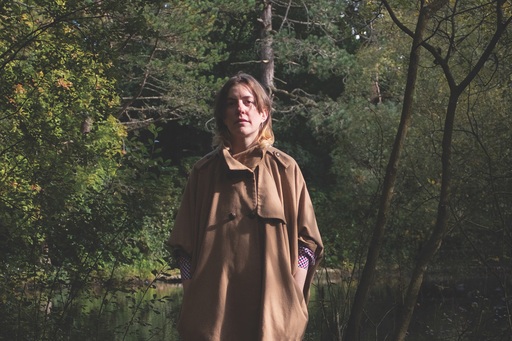 Photo of LT Leif in a brown jacket in front of a lake