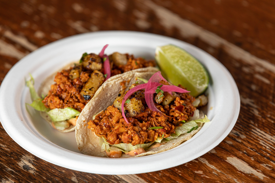 Two Al Pastor tacos on a white plate.