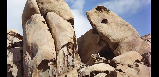 An image of large rocks, with a blue sky behind