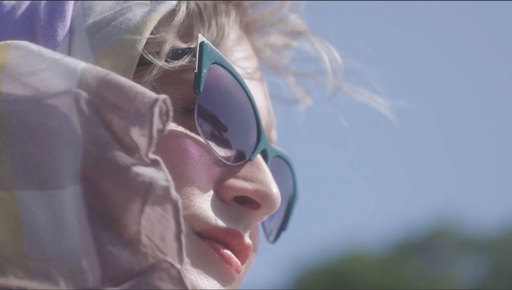A still from Framing Agnes. A woman in a headscarf and sunglasses looks into the distance.
