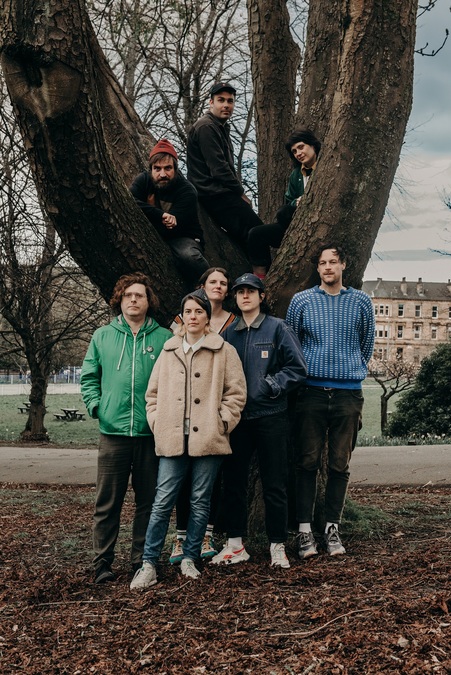 The members of Lost Map presents Weird Wave, standing in front of and around a large tree.