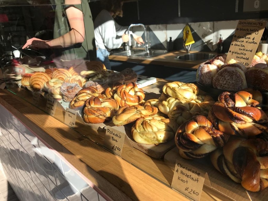 A bakery window filled with pastries; light shines in from the window.