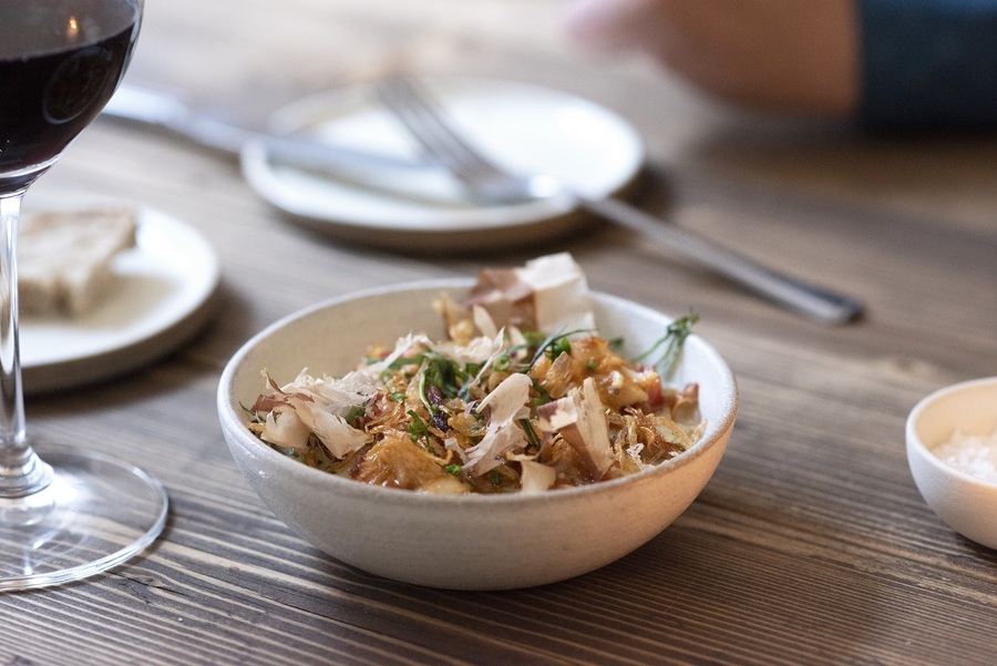 A bowl of food on a wooden table.