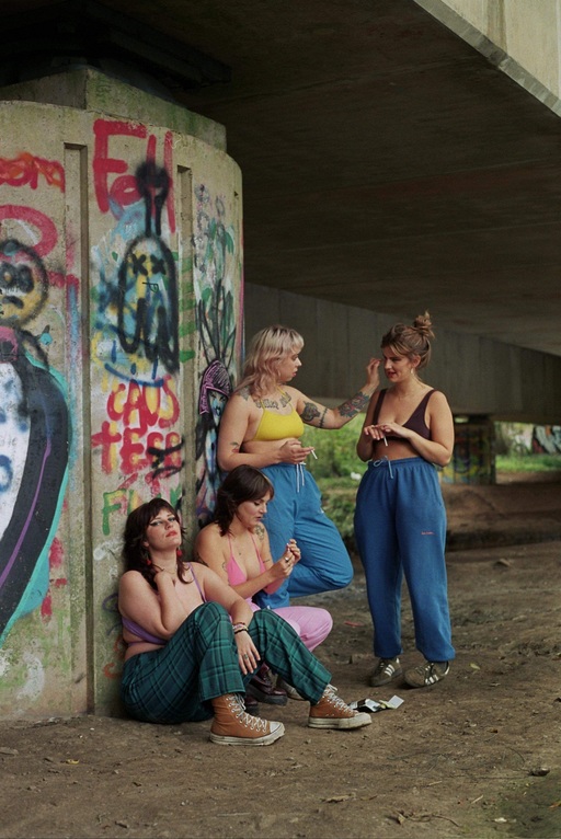 The members of Panic Shack pose next to the grafitti'd concrete of an underpass