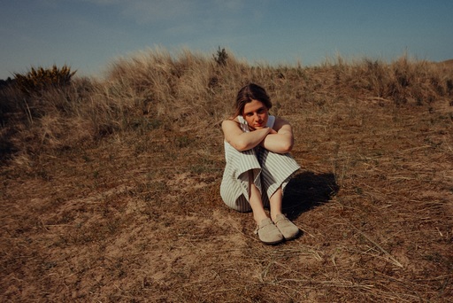 Rosie H Sullivan, sitting on a grassy hill.