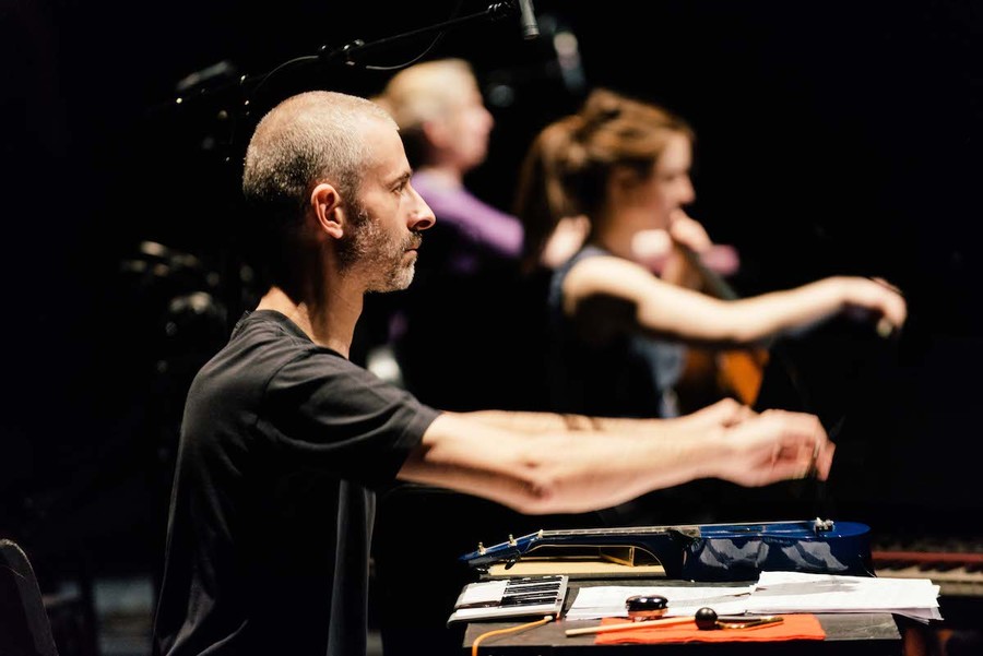 A musician plays a percussion instrument on stage.