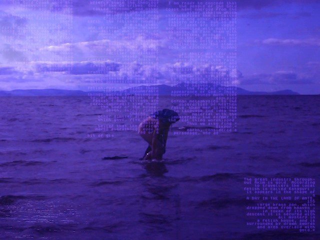 A still from film by artist Kialy Tihngang. A figure stands in shallow water; the image is tinted in shades of purple, with paragraphs of text and numbers overlaid across the image.