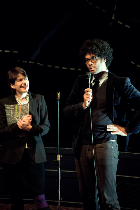 Photograph of Allison Gardner and Richard Ayoade on stage with microphones.