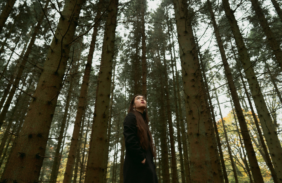 Photo of Miwa Nagato-Apthorp, standing amid a forest.