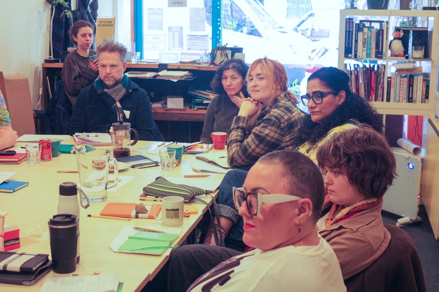 Photo of a group at a writing workshop, sitting around a large table.