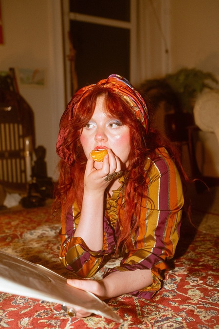 Photo of Megan Black eating an orange.