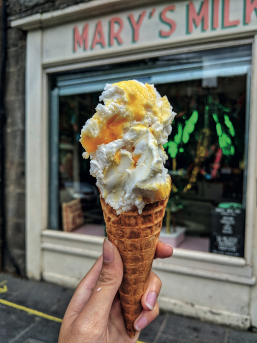 Photo of a hand holding an ice cream outside Marys Milk Bar.
