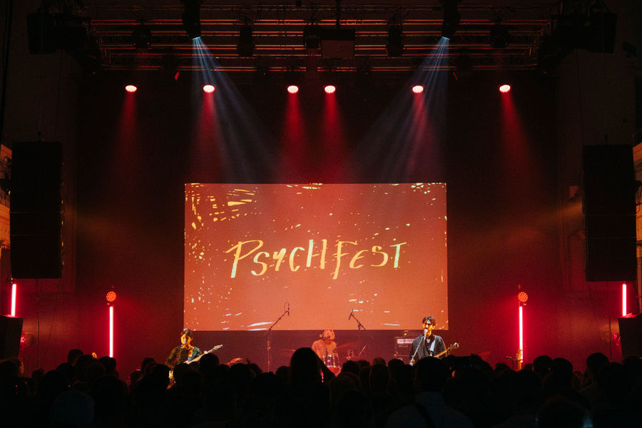 Honeyglaze on stage at Edinburgh Psych Fest, with a projection of the words 'Psych Fest' behind the band.