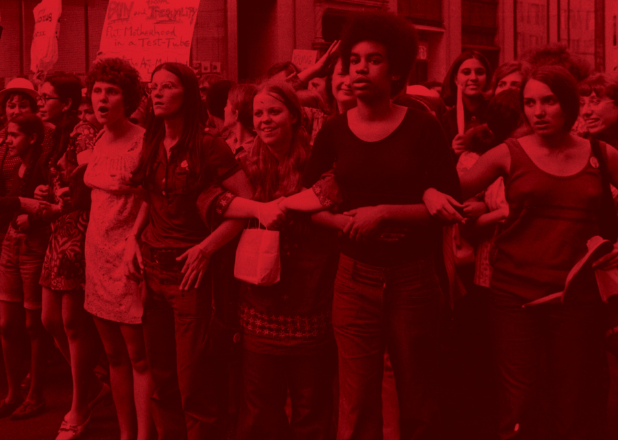 A red-tinged photo of a marching group of young people.