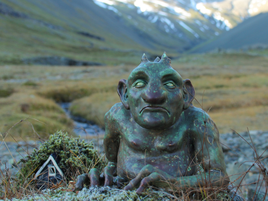 Photo of a ceramic troll in an outdoor setting.