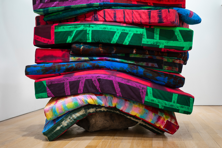 Photograph of artwork The Grit by Eva Rothschild. A stack of colourful rectangular pieces of soft material.